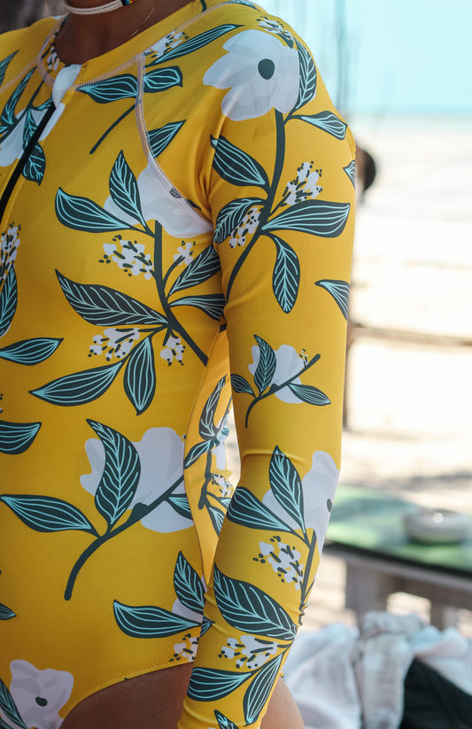 long sleeve surf suit rash guard from lycra with front zipper for women with a print with yellow base and white lotus flowers with leaves