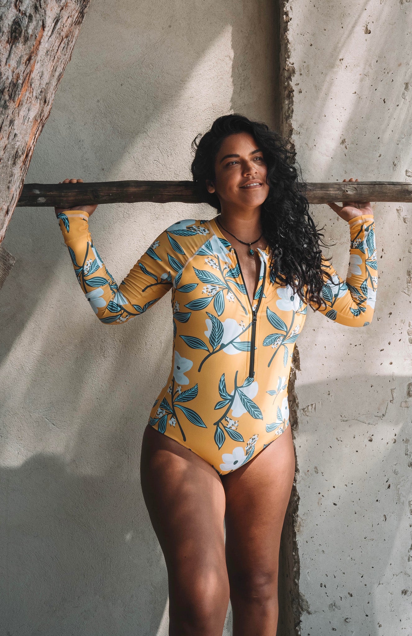 long sleeve surf suit rash guard from lycra with front zipper for women with a print with yellow base and white lotus flowers with leaves