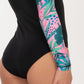 one piece, swimsuit, long sleeve, black body, printed sleeves, pink print with leaves and dots, close up, booty, medium coverage